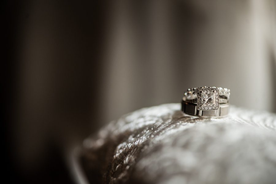 Wedding rings sit on a pillow at the Belvedere Hotel in Baltimore, MD. Captured by Ben Lau Photography.