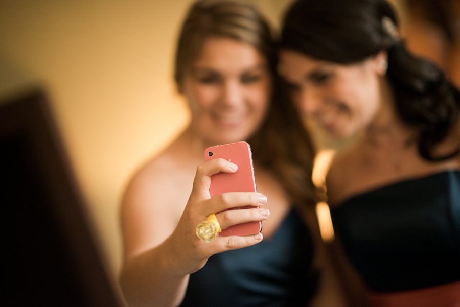 Bridesmaids take photos of themselves at a wedding at the Crystal Plaza in Livingston, NJ. Captured by NJ wedding photographer Ben Lau.