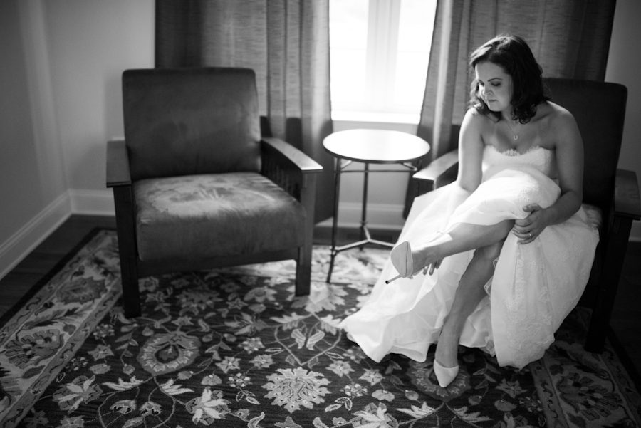 Bride slips on her shoes for her wedding at Mercer Oaks in Princeton Junction, NJ. Captured by NJ wedding photographer Ben Lau.