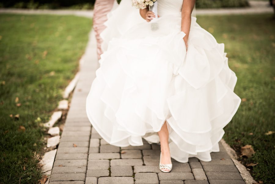 Bride walks down a path on the morning of her wedding at The Mill in Spring Lake Heights, NJ. Captured by northern NJ wedding photographer Ben Lau.
