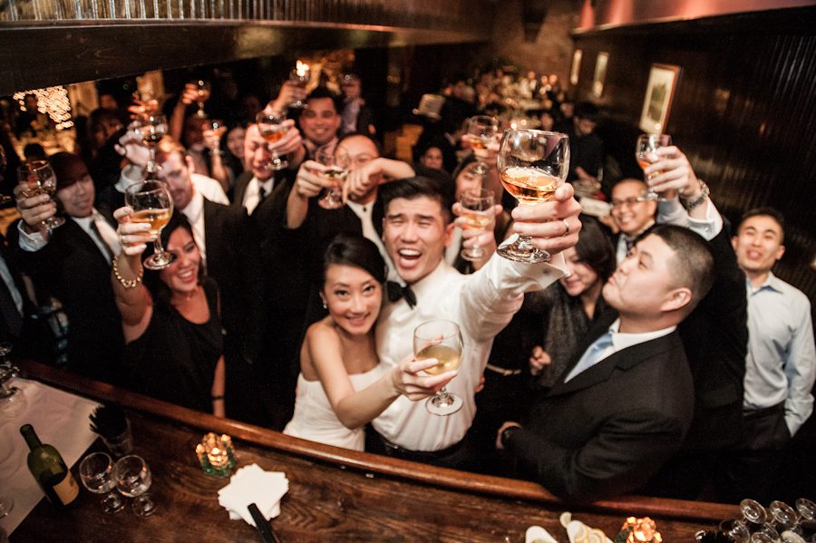 Guests share a toast during a wedding at Morans in Chelsea, NY. Captured by NYC wedding photographer Ben Lau.