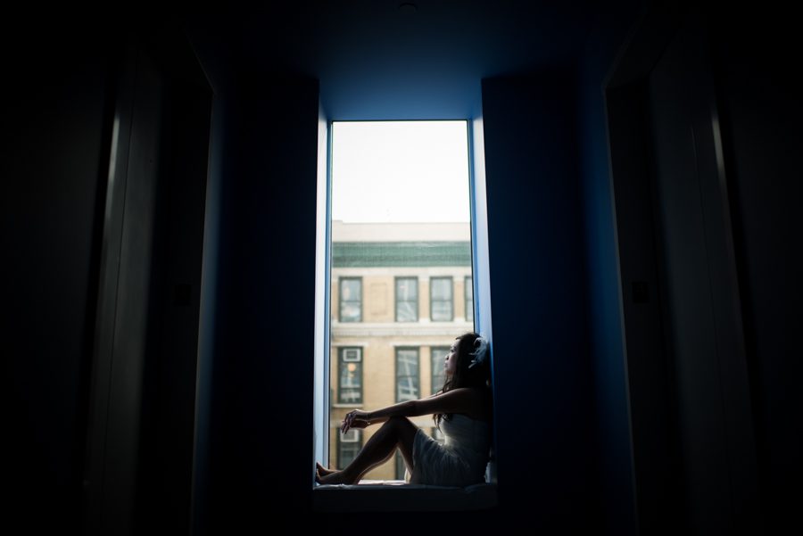 Bride poses for a portrait by the window at the Mondrian Hotel before her New York City Hall wedding. Captured by NYC wedding photographer Ben Lau Photography.