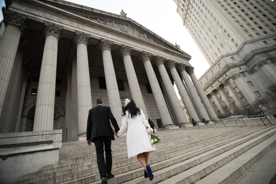 Couple ascends the stairs before their New York City Hall wedding. Captured by NYC wedding photographer Ben Lau Photography.