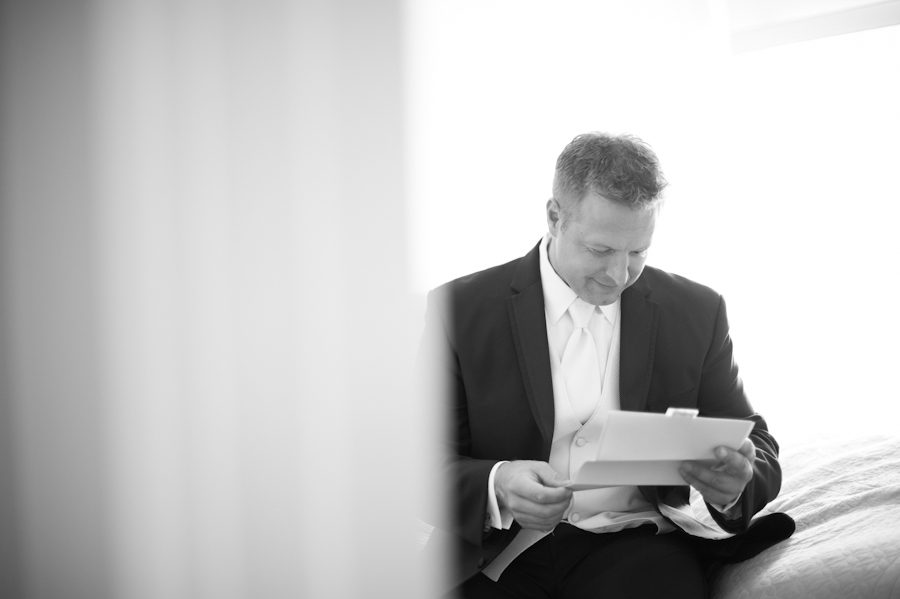 Groom reads a letter from his bride on the morning of his wedding day at Clarks Landing in Point Pleasant, NJ. Captured by northern NJ wedding photographer Ben Lau.