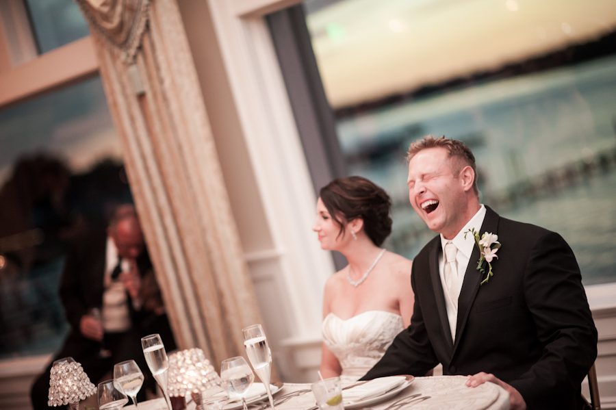 Groom laughs during speeches at his wedding reception at Clarks Landing in Point Pleasant, NJ. Captured by northern NJ wedding photographer Ben Lau.