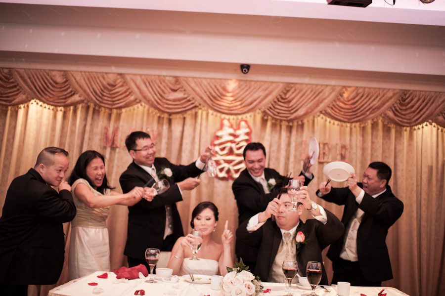 Entire bridal party taps their glasses during a wedding reception at Mudan's in Flushing, NY. Captured by Ben Lau Photography.