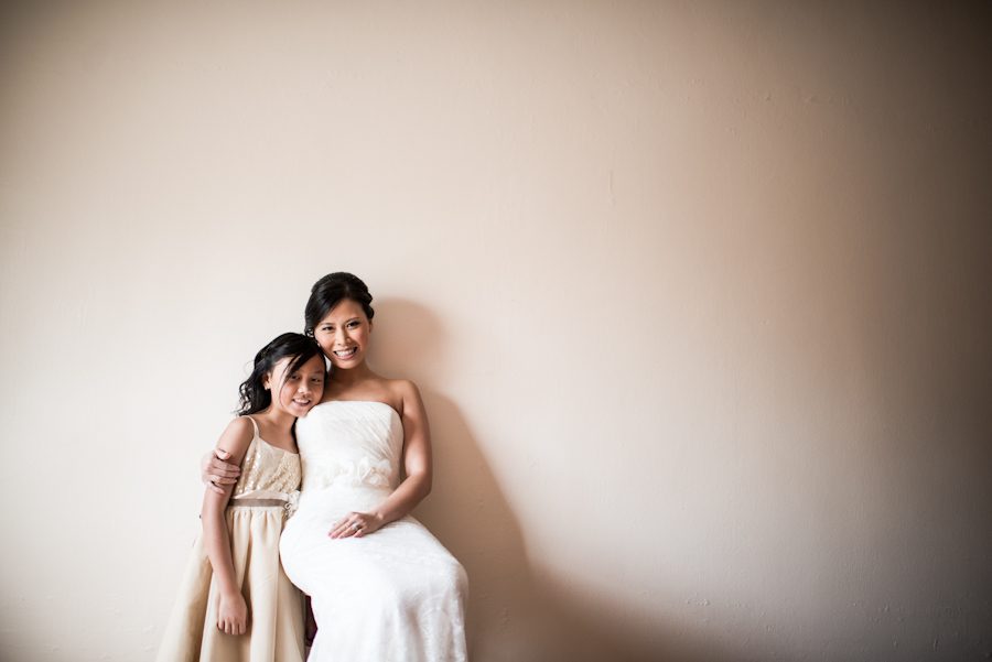 Bride poses with her daughter during portraits on her wedding day in Brooklyn, NY. Captured by Ben Lau Photography.