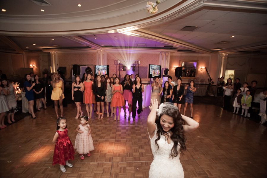 Bouquet toss at a wedding reception at the VIP Country Club in Westchester, NY. Captured by NYC wedding photographer Ben Lau.