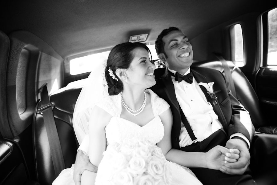 Bride laughs in the limo ride to her wedding reception in NJ. Captured by Ben Lau Photography.