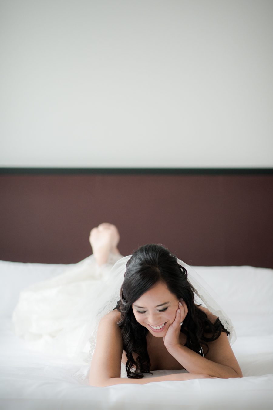 Bride smiles as she poses in her suite at the Bryant Park Hotel in New York City.