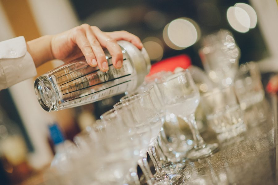 Bartender pours a row of drinks during a Douglaston Manor Wedding. Captured by NYC wedding photographer Ben Lau.
