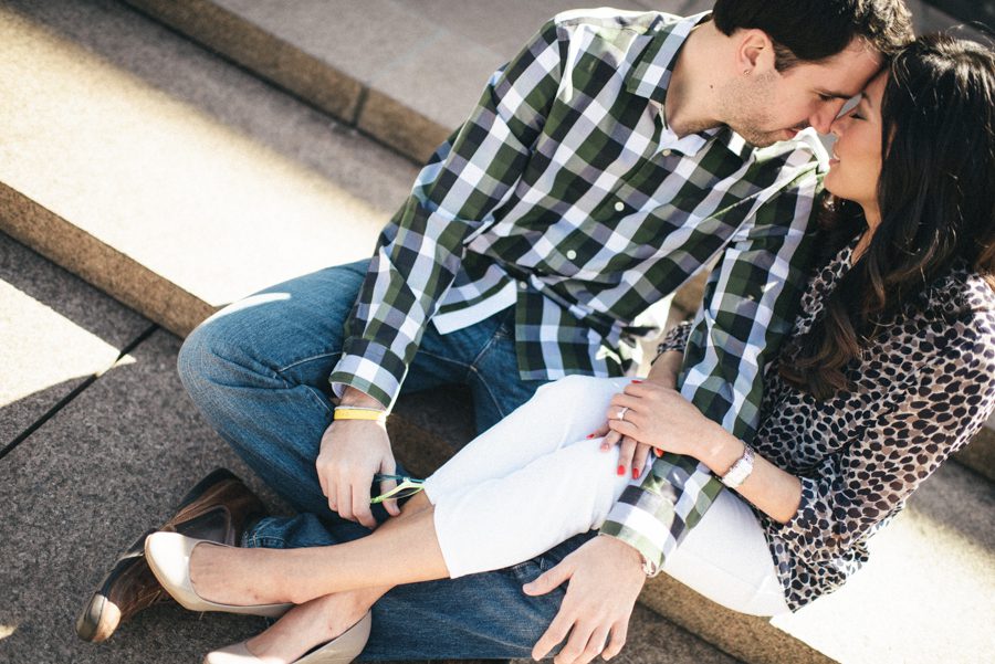 Julia and Jeff sit on the steps during their engagement session at a Princeton University library.