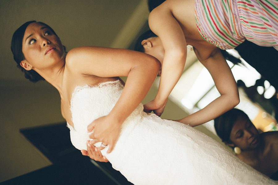 Bride puts on her dress at the Radisson Aruba. Captured by destination wedding photographer Ben Lau.