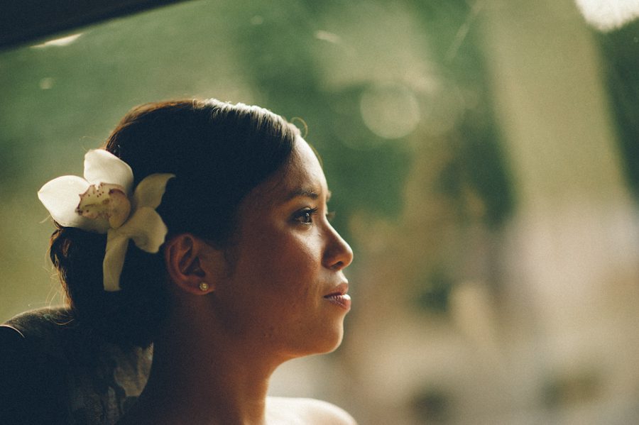 Bride looks out the window while on her way to her wedding at the Radisson Aruba. Captured by destination wedding photographer Ben Lau.
