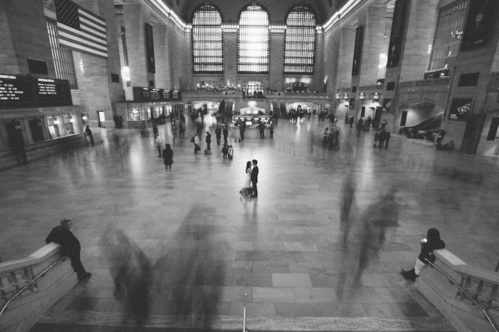 Couple poses in the main concourse of Grand Central Station during their engagement session in NYC. Captured by NYC wedding photographer Ben Lau.
