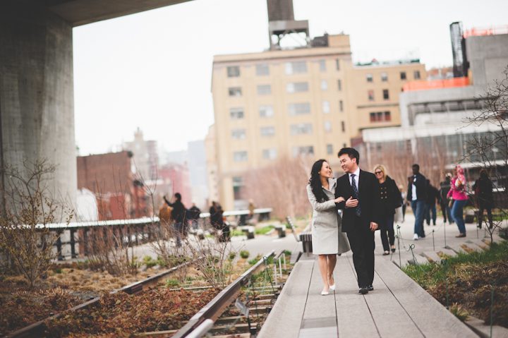 Couple walk along the High Line during their engagement session in NYC. Captured by NYC wedding photographer Ben Lau.