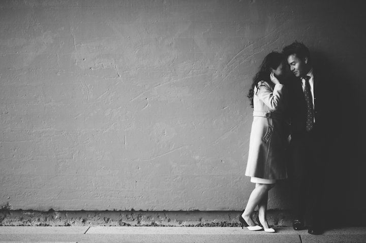 Couple pose against a wall during their engagement session in NYC. Captured by NYC wedding photographer Ben Lau.