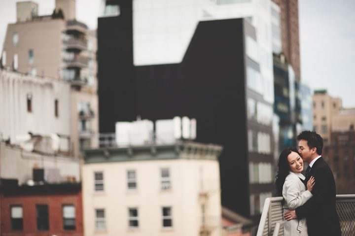 Couple pose against a railing during their engagement session in NYC. Captured by NYC wedding photographer Ben Lau.