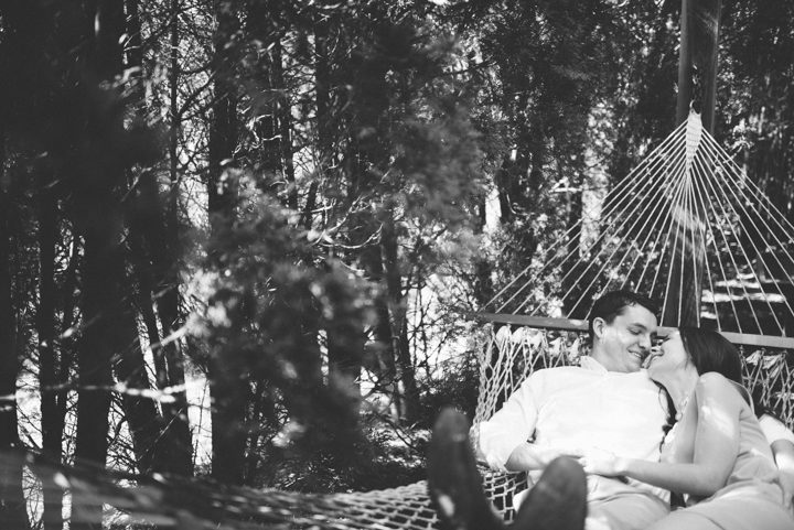 Couple rests on a hammock during their engagement session at the Grounds for Sculpture in Hamilton, NJ. Captured by NJ wedding photographer Ben Lau.