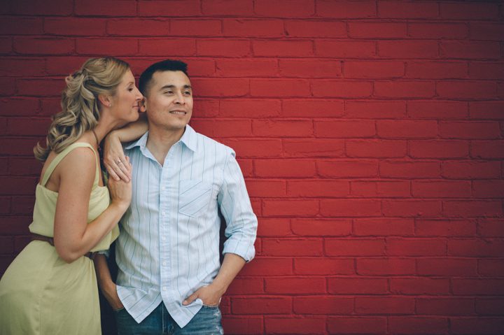 Couple poses on a wall in Annapolis during their engagement session, captured by Annapolis wedding photographer Ben Lau.