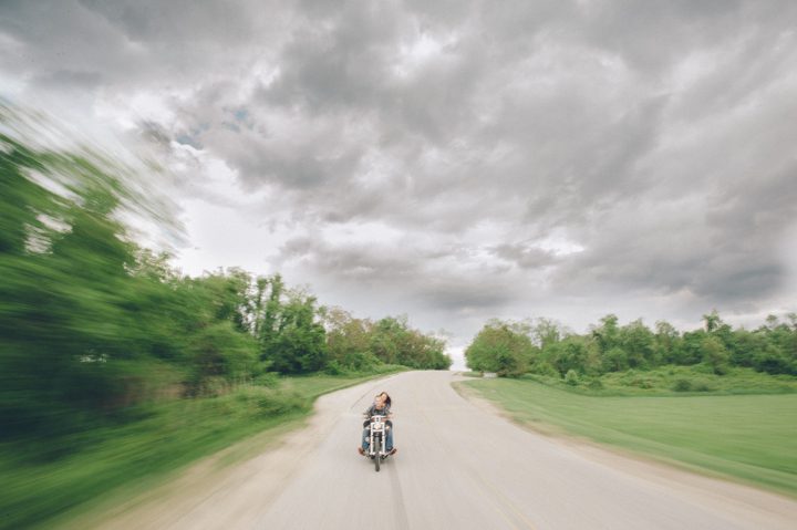 Couple rides a bike through stormy clouds during a Baltimore engagement session with Ben Lau Photography.