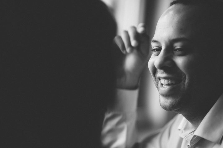 Guy smiles in a coffee shop in Jersey City during an engagement session with NYC wedding photographer Ben Lau.