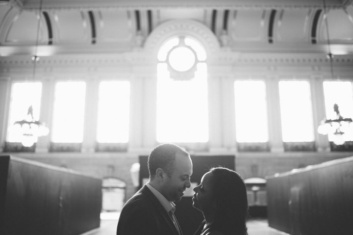 Couple kisses in the main lobby of the Hoboken train station during an engagement session with NYC wedding photographer Ben Lau.