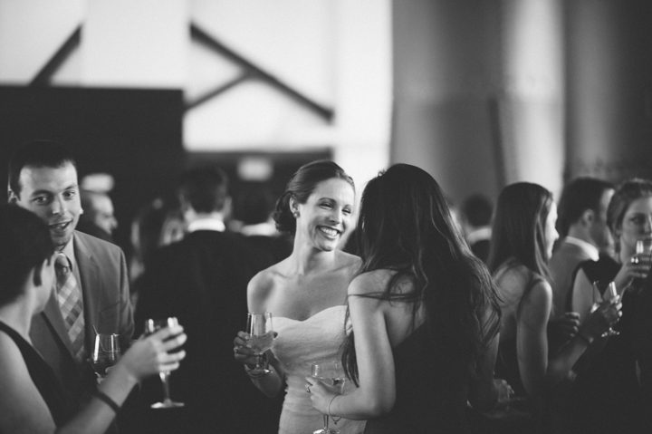 Bride mingles with the guests during cocktail hour at the Phoenixville Foundry in Phoenixville, Pa. Captured by Northern NY wedding photographer Ben Lau.