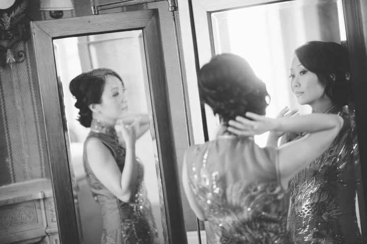 Bride checks herself in the mirror on the morning of her wedding at the Hempstead House in Sands Point Preserve, Long Island. Captured by NYC wedding photographer Ben Lau.