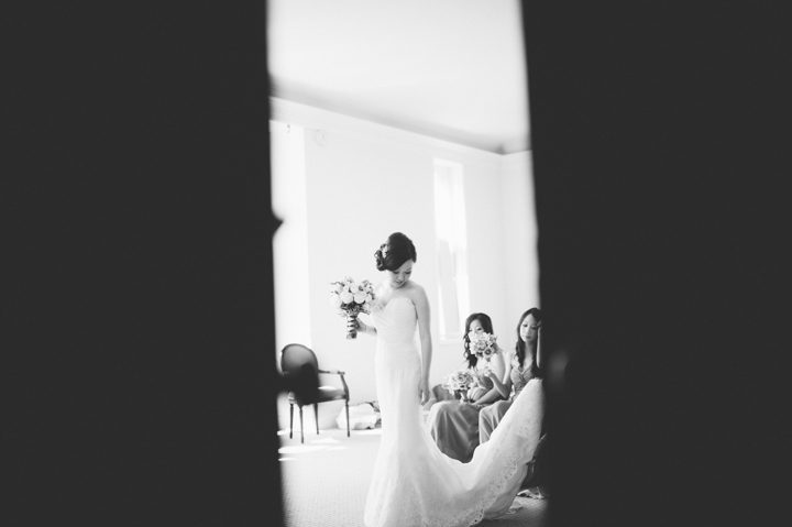 Bride fixes her dress on the morning of her wedding at the Hempstead House in Sands Point Preserve, Long Island. Captured by NYC wedding photographer Ben Lau.