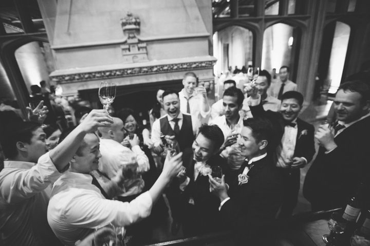 Big toast during a wedding reception at the Hempstead House in Sands Point Preserve, Long Island. Captured by NYC wedding photographer Ben Lau.