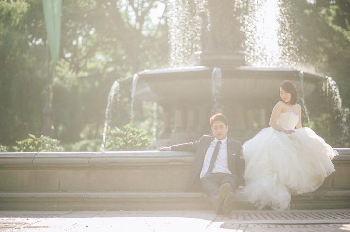 Bride and groom poses by the fountain in Central Park during during their bridal session with NYC wedding photographer Ben Lau.