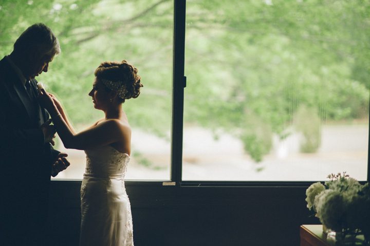 Bride adjusts her father's flowers on the morning of her wedding day at the Old Tappan Manor in Old Tappan, NJ. Captured by Northern New Jersey Wedding Photographer Ben Lau.