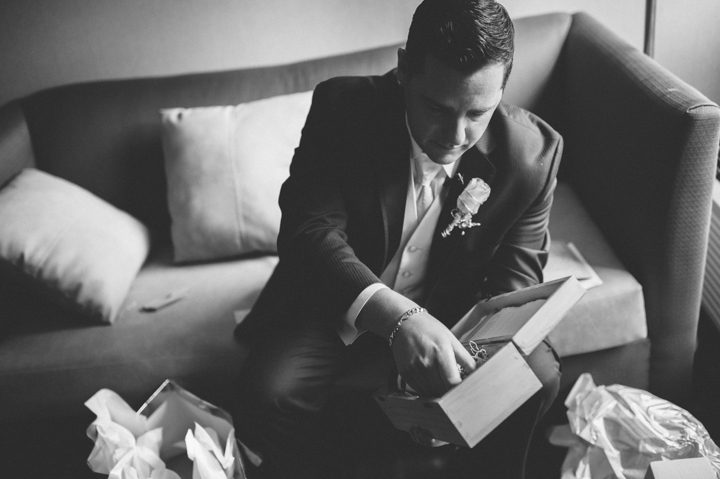 Groom opens his gift on his wedding day at the Old Tappan Manor in Old Tappan, NJ. Captured by Northern New Jersey Wedding Photographer Ben Lau.
