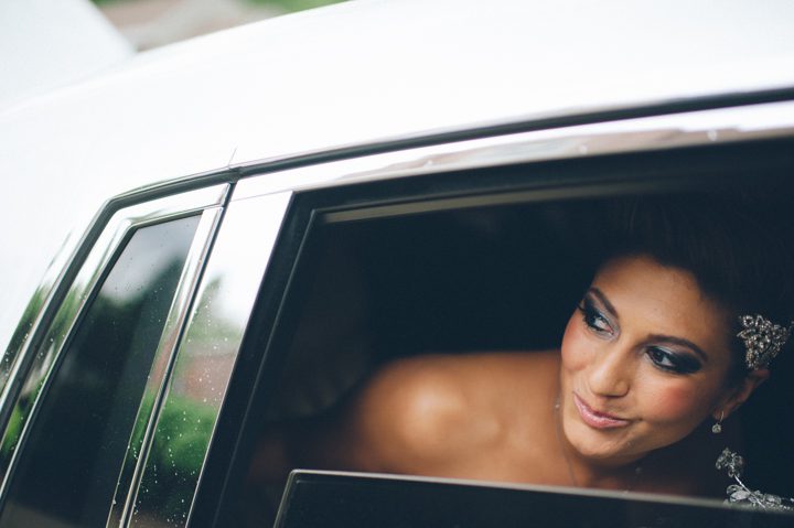 Bride looks outside the window as she arrives to her reception at the Old Tappan Manor in Old Tappan, NJ. Captured by Northern New Jersey Wedding Photographer Ben Lau.