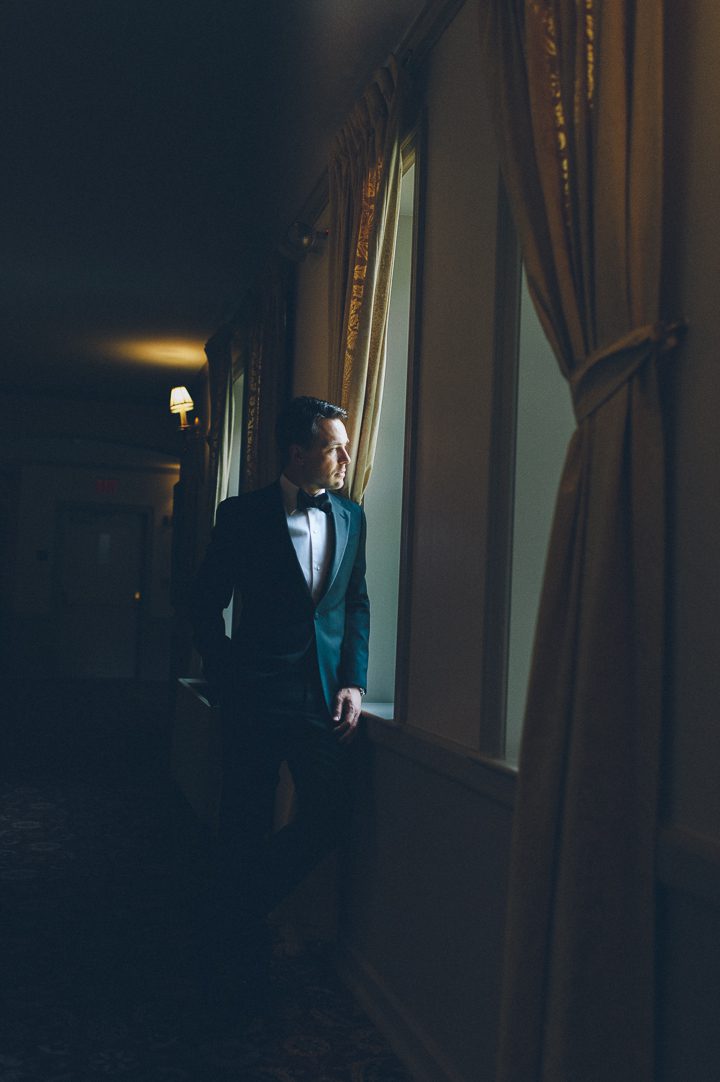 Groom portrait by the window at the Castle on the Hudson in Tarrytown, NY. Captured by NYC wedding photographer Ben Lau.