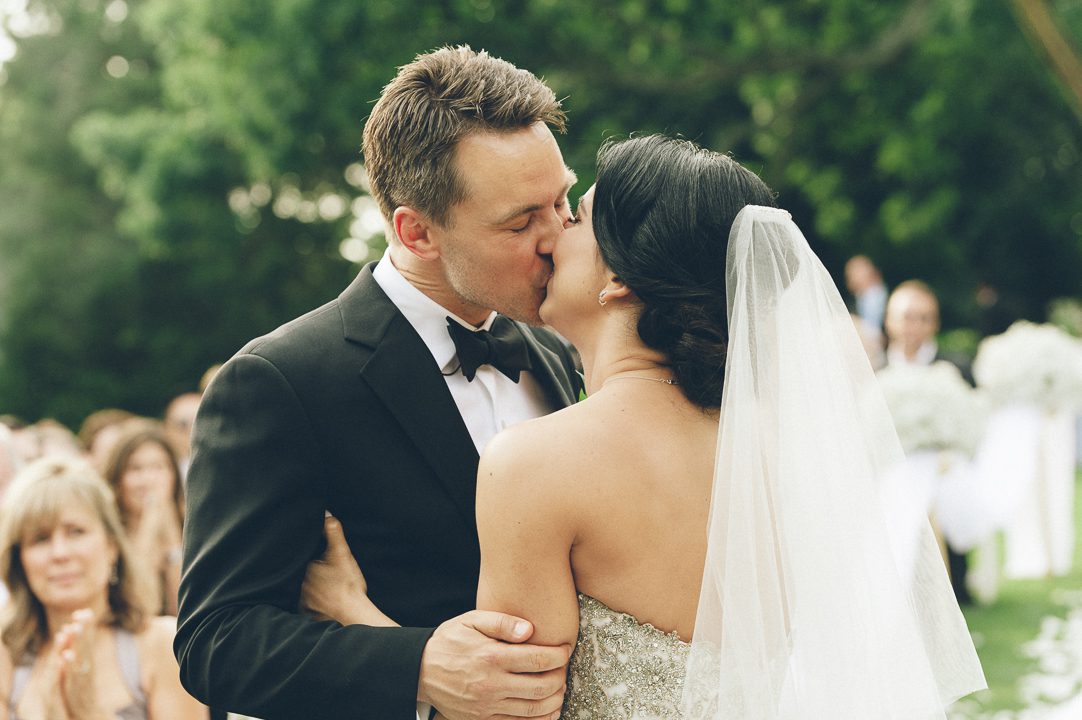 Bride and groom's first kiss during their wedding cermeony at the Castle on the Hudson in Tarrytown, NY. Captured by NYC wedding photographer Ben Lau.