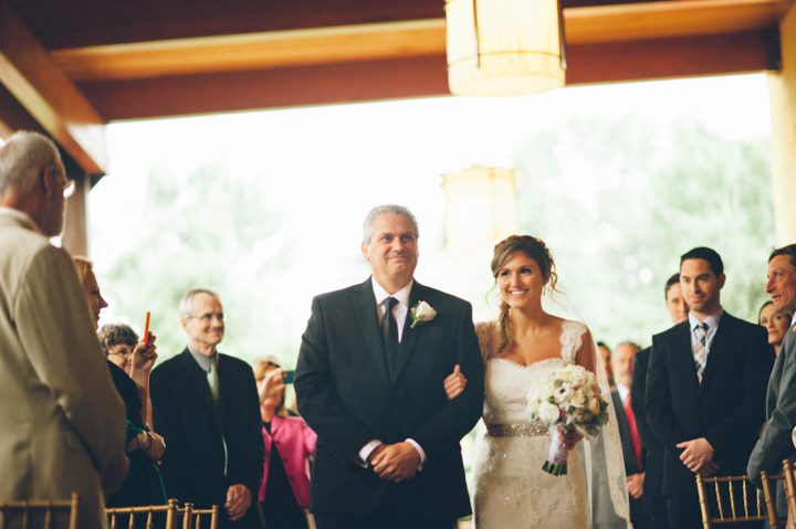 Father walks his daughter down the aisle during a wedding ceremony at the Stone House in Stirling Ridge. Captured by NJ wedding photographer Ben Lau.