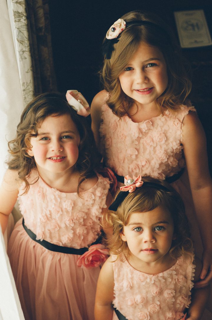 Flower girls stand by a window at the Stone House at Stirling Ridge. Captured by NJ Wedding Photographer Ben Lau.