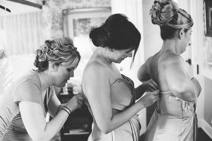 Bridesmaids slip into their dresses at the Antrim 1844 Country House in Taneytown, MD. Captured by Baltimore wedding photographer Ben Lau.