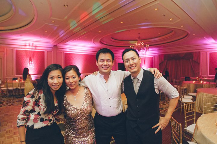Ben Lau and Karis Lau pose with bride and groom during a wedding reception at the Ritz Carlton in San Francisco, CA. Captured by NYC wedding photographer Ben Lau.