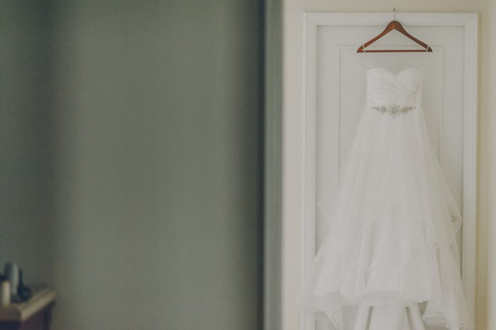 Wedding dress hangs by the door at the Ritz Carlton in San Francisco, CA. Captured by NYC wedding photographer Ben Lau.