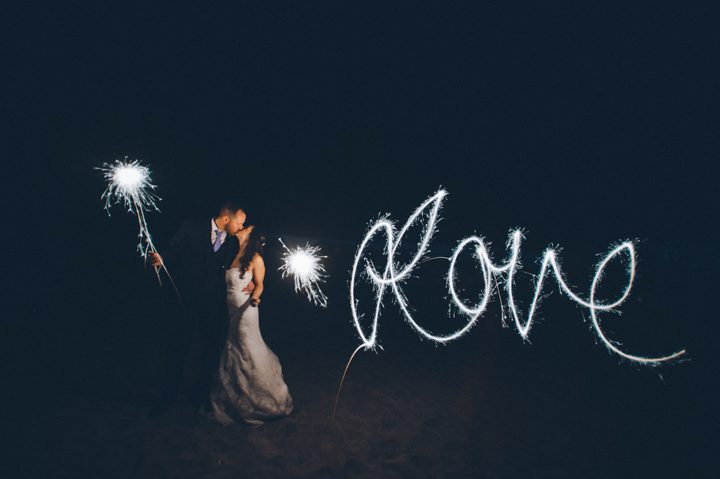Sparkler Wedding Photo On The Beach. Captured by NYC wedding photographer Ben Lau.