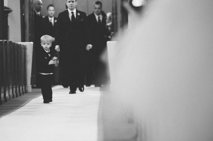 Ring bearer runs down the aisle during a St. Peter the Apostle Church wedding in New Brunswick, NJ. Captured by NJ wedding photographer Ben Lau.