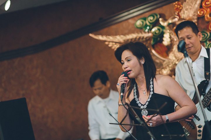 Guest sings during a wedding reception at China Garden in Rosslyn, Northern Virginia. Captured by NYC wedding photographer Ben Lau.
