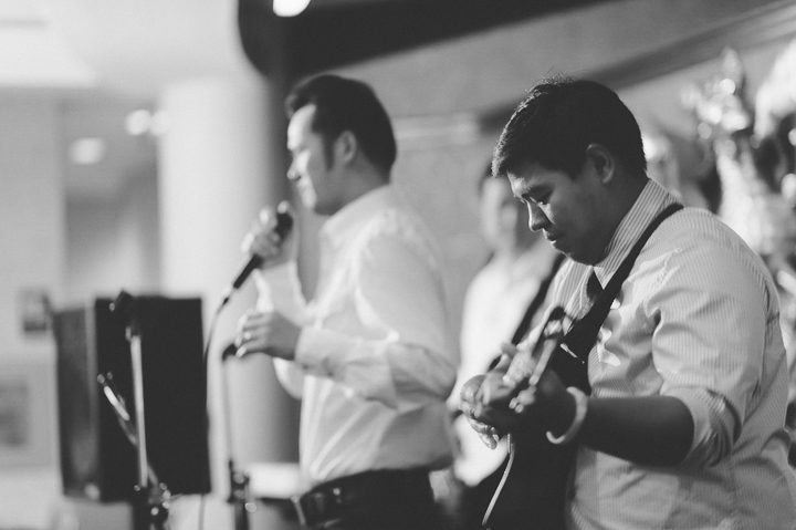 Guest plays the guitar during a wedding reception at China Garden in Rosslyn, Northern Virginia. Captured by NYC wedding photographer Ben Lau.