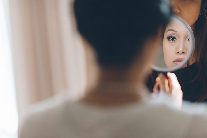 Bride looks into the mirror on the morning of her wedding at the Le Meridian in Crystal City - Northern Virginia. Captured by NYC wedding photographer Ben Lau.