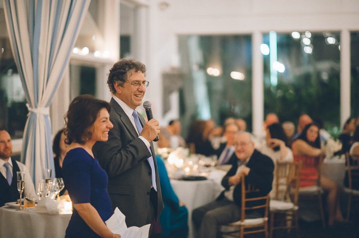 Parents of the bride make a toast during wedding reception at Oceanblue/Westhampton Bath & Tennis in Westhampton, NY. Captured by NYC wedding photographer Ben Lau.