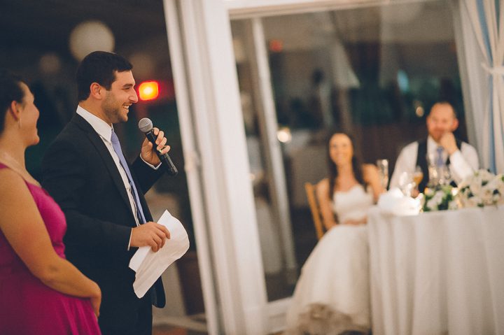 Brother of the bride makes a toast during a wedding reception at Oceanblue/Westhampton Bath & Tennis in Westhampton, NY. Captured by NYC wedding photographer Ben Lau.