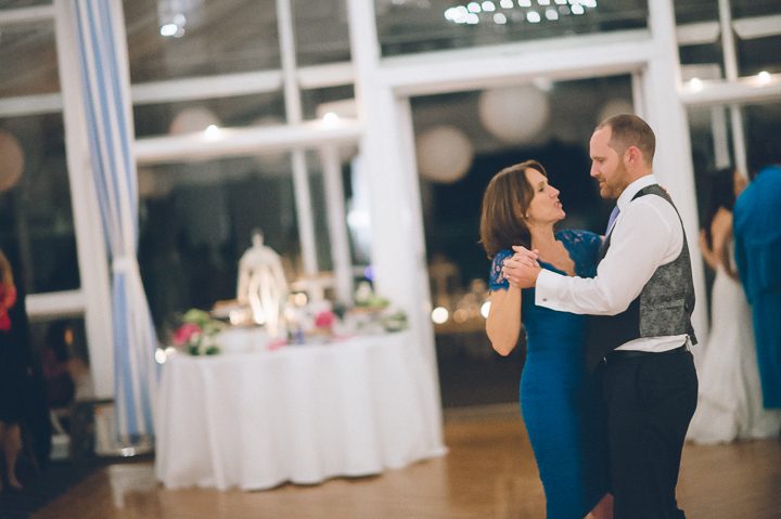 Groom and his mother dance during a wedding reception at Oceanblue/Westhampton Bath & Tennis in Westhampton, NY. Captured by NYC wedding photographer Ben Lau.